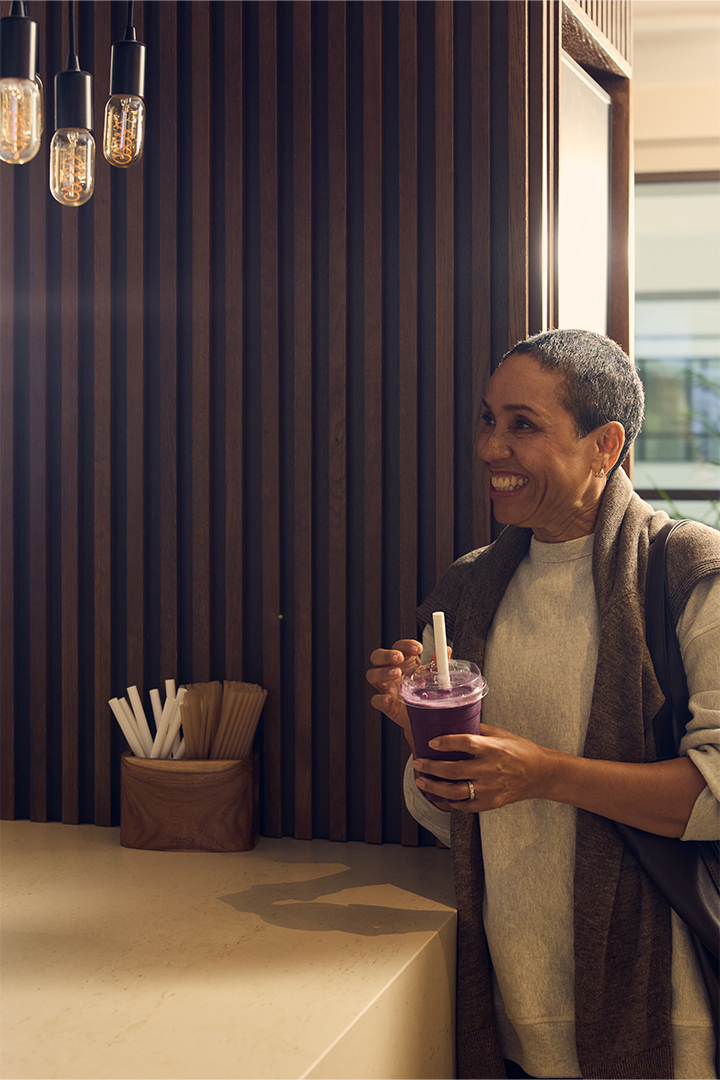 A woman ordering a juice at the Juice Bar at Dolphin House in Pimlico